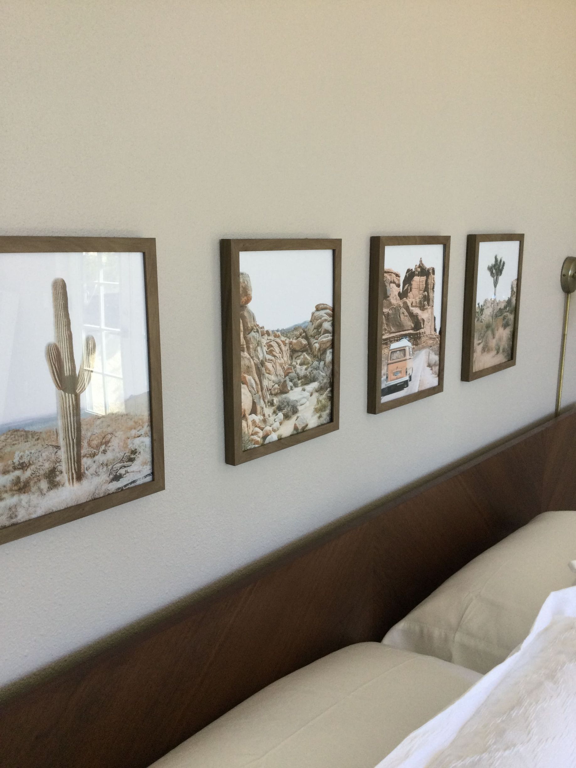 A bedroom with pictures on the wall above the bed