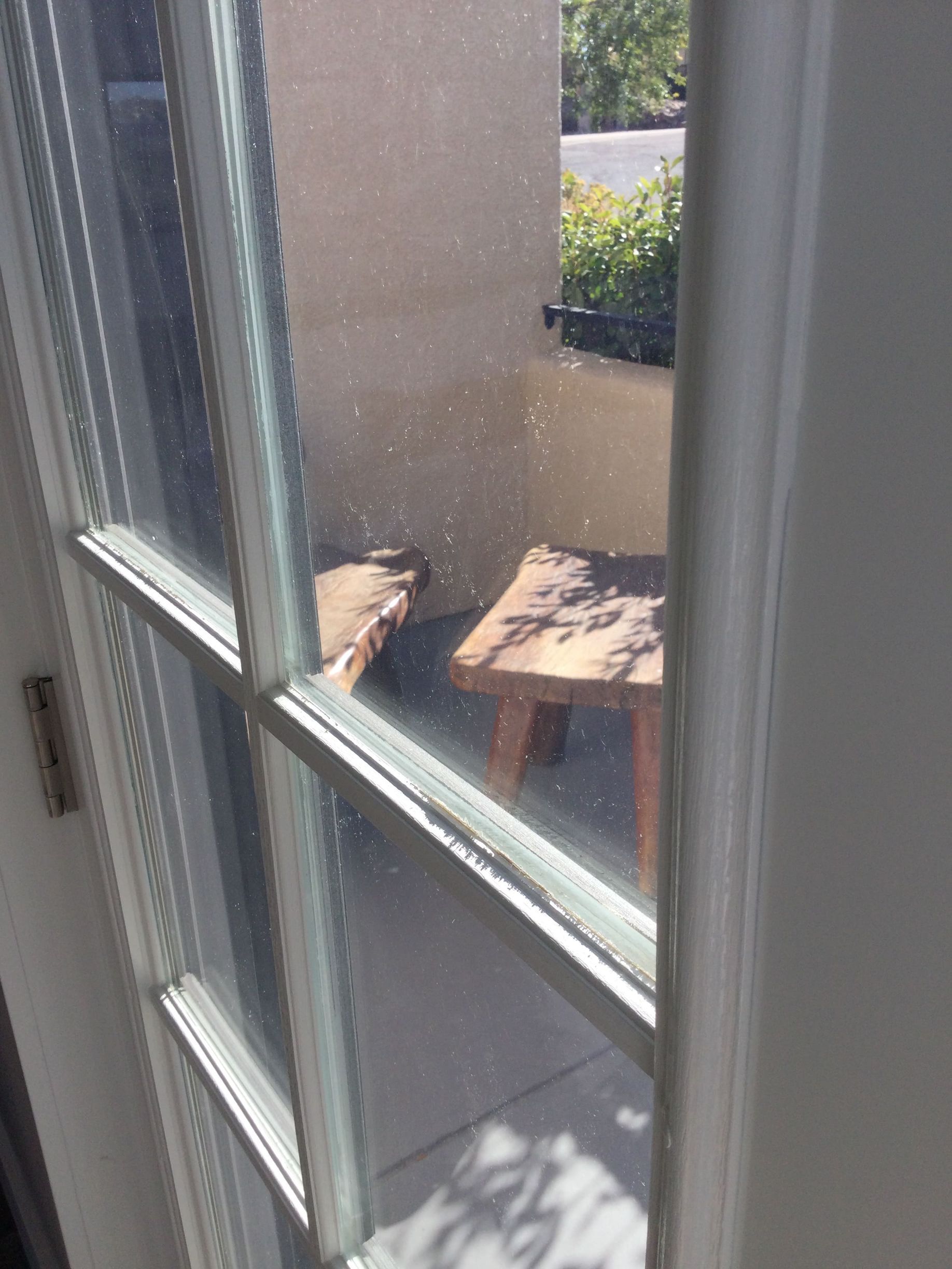 A close up of a window with a table in the background.