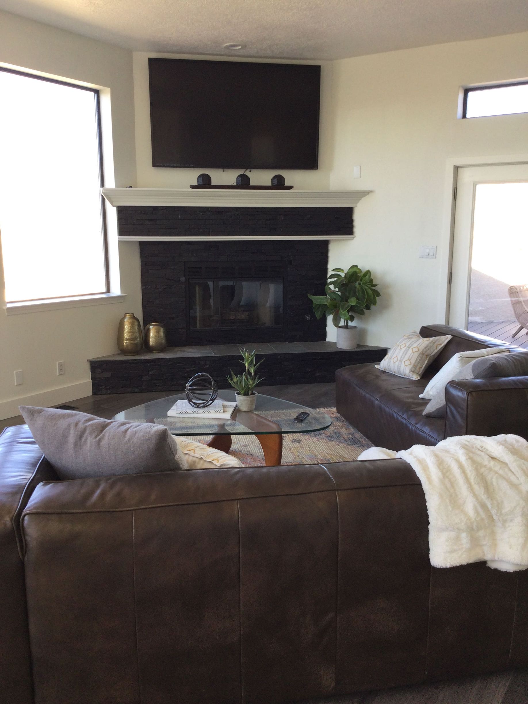 A living room with a couch , fireplace and television.