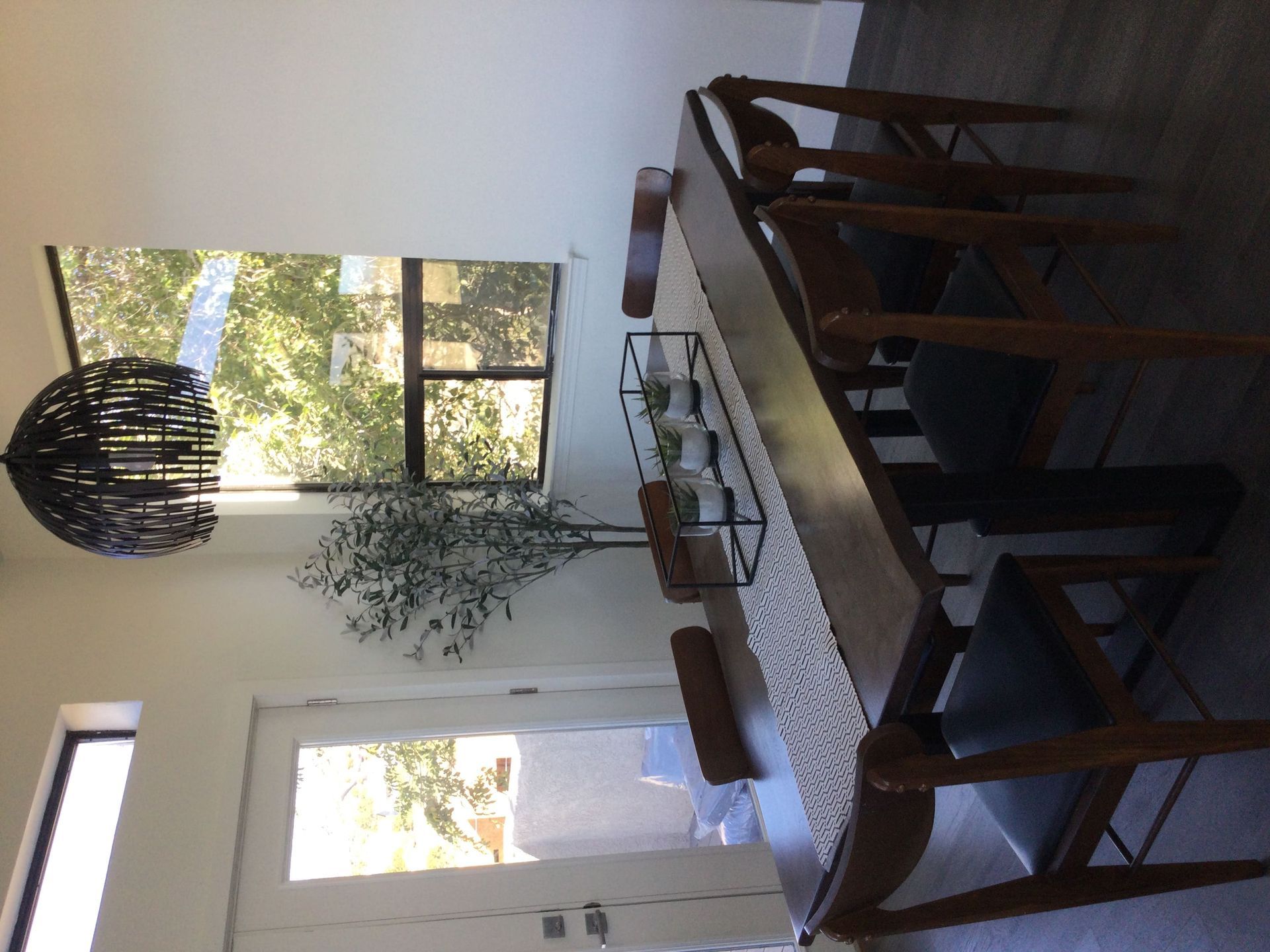 A dining room with a table and chairs and a window