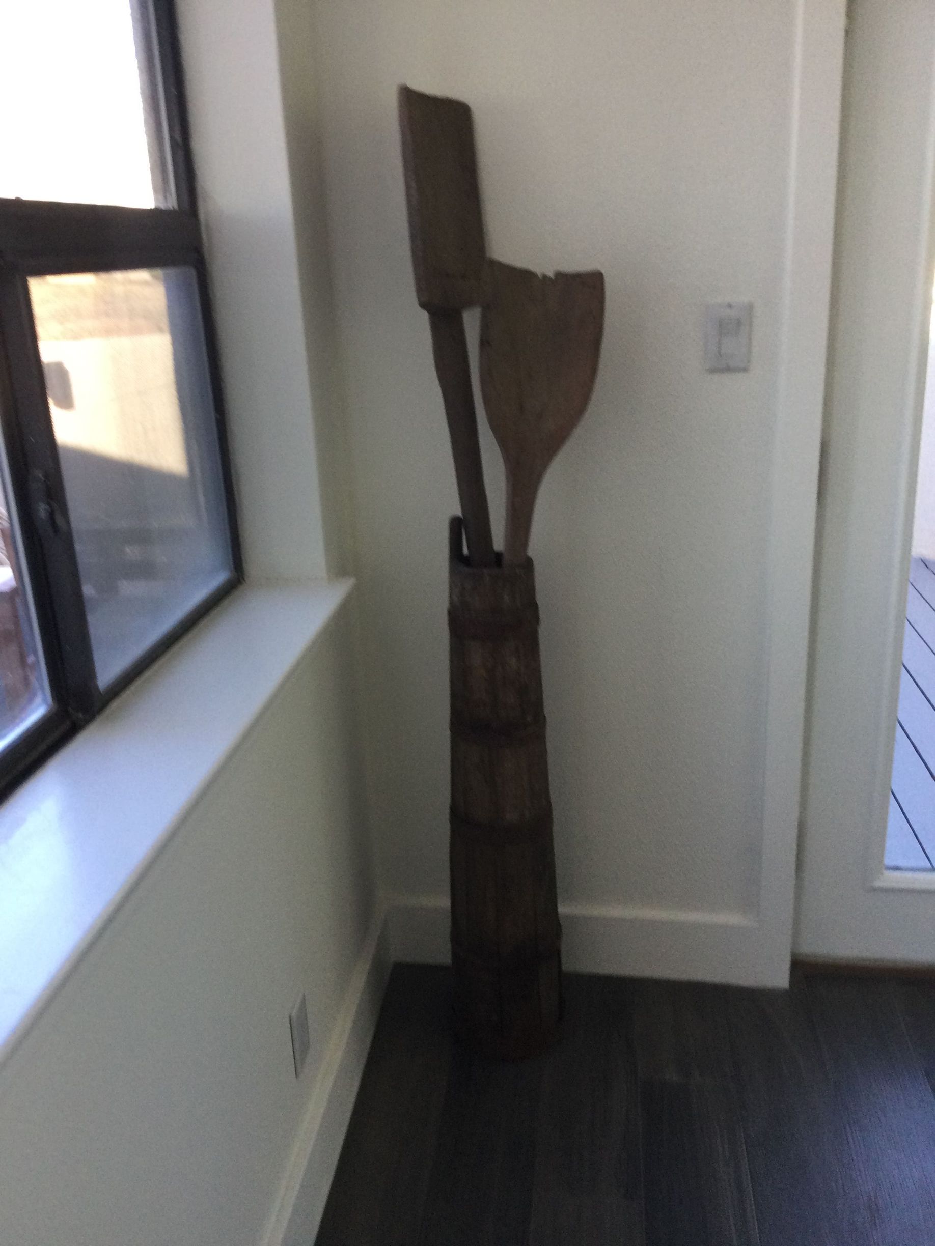 A wooden sculpture in a room next to a window
