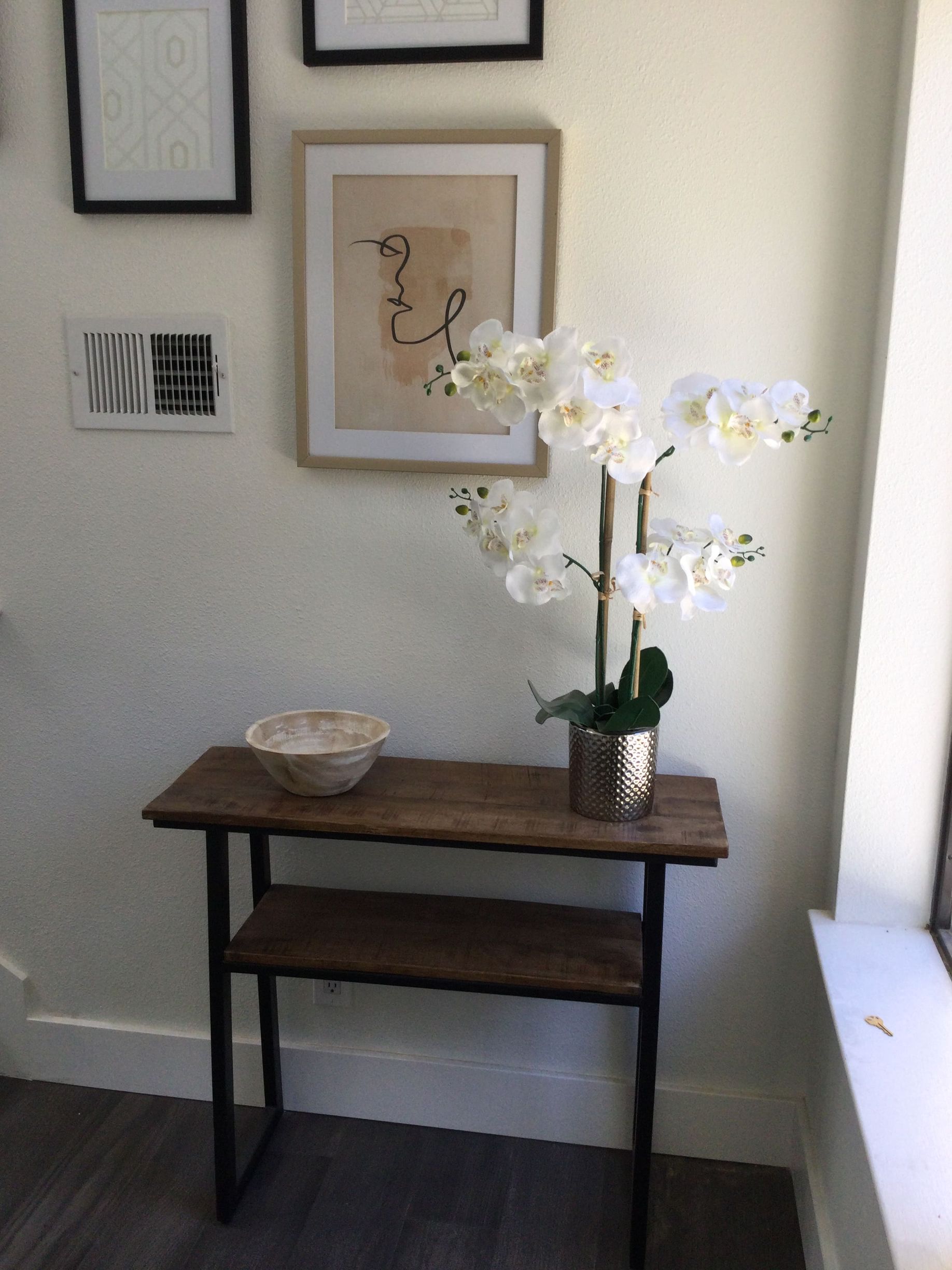 A wooden table with a vase of flowers on it