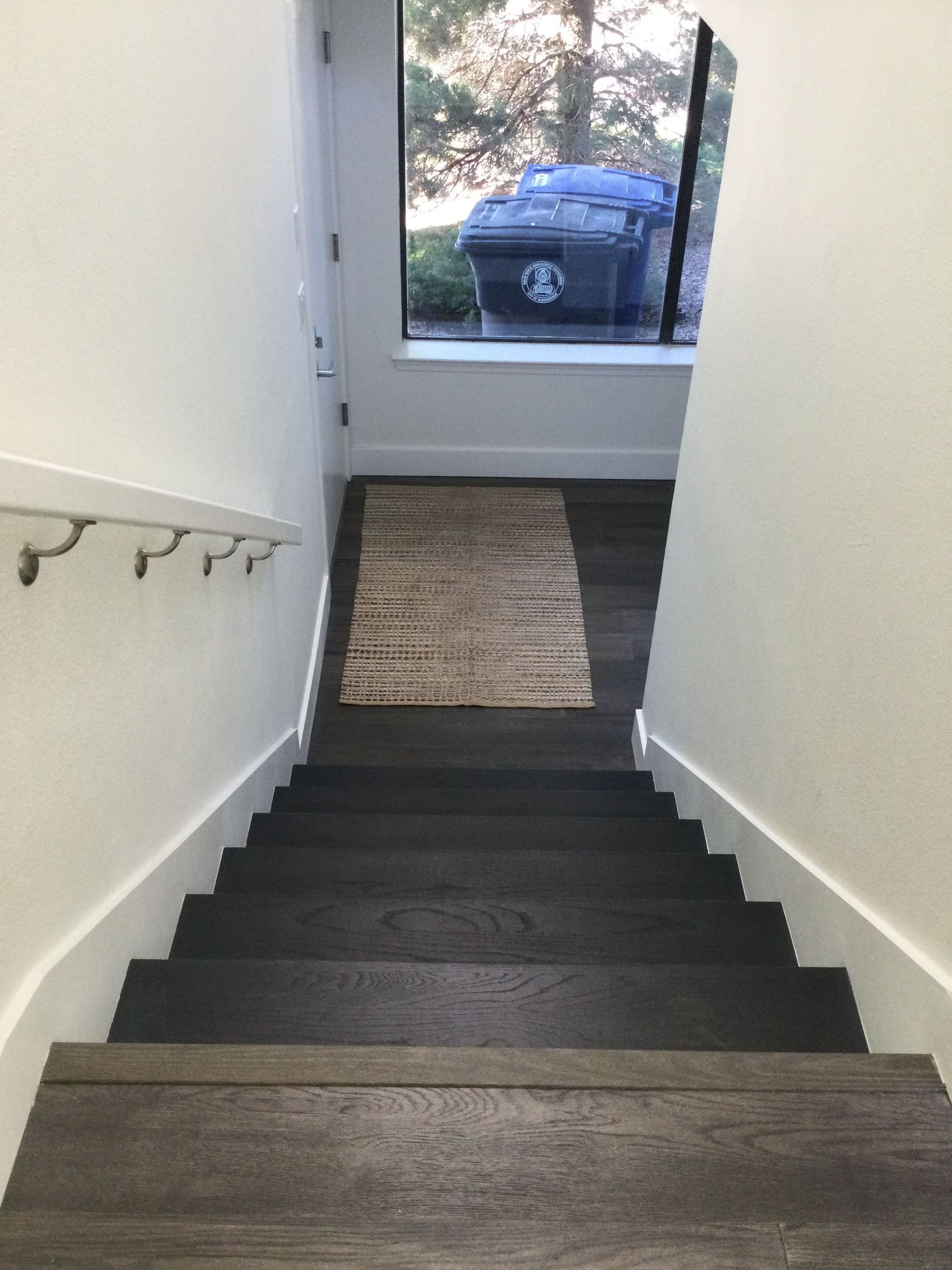 Stairs leading up to a room with a trash can in the window