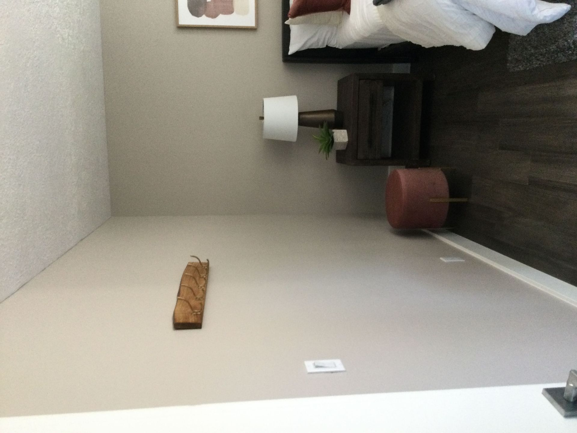 A bedroom with a bed and a lamp on the wall