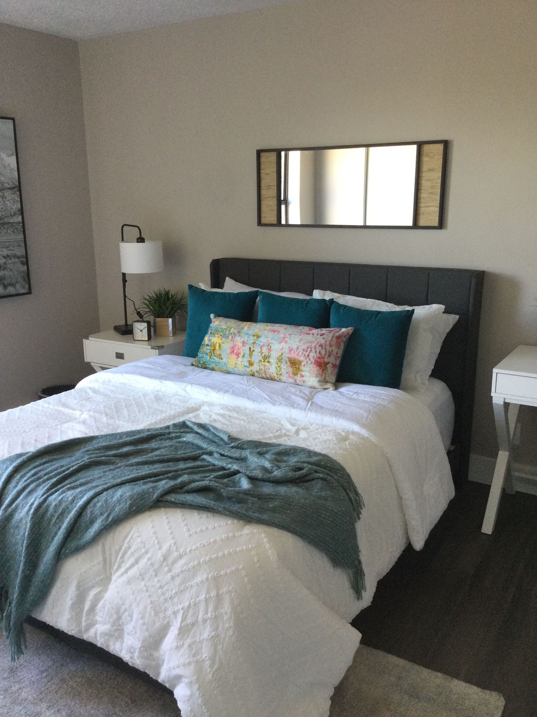 A bedroom with a bed and a mirror on the wall