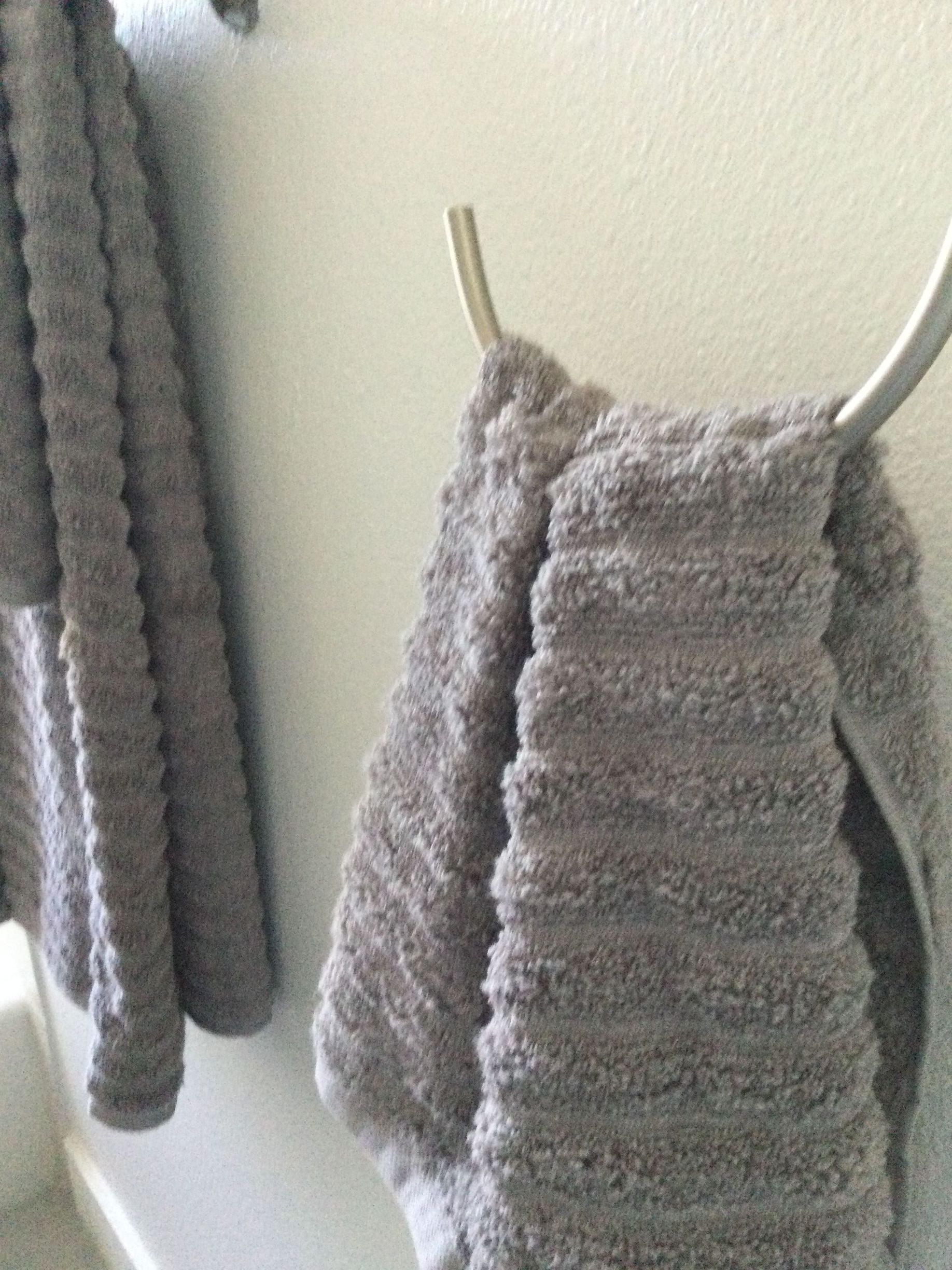 Two towels are hanging on a towel rack in a bathroom.