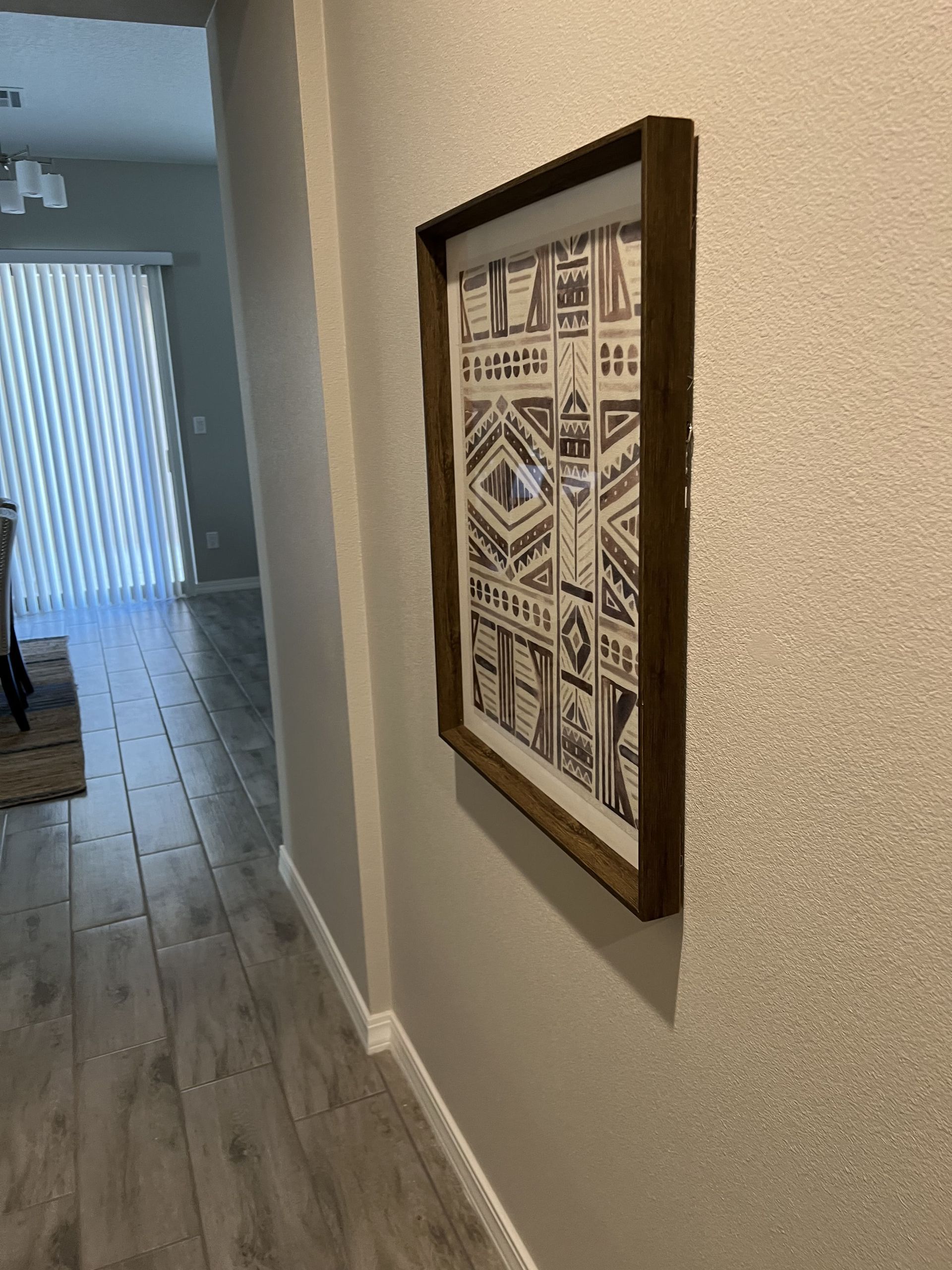 A picture is hanging on a wall in a hallway.