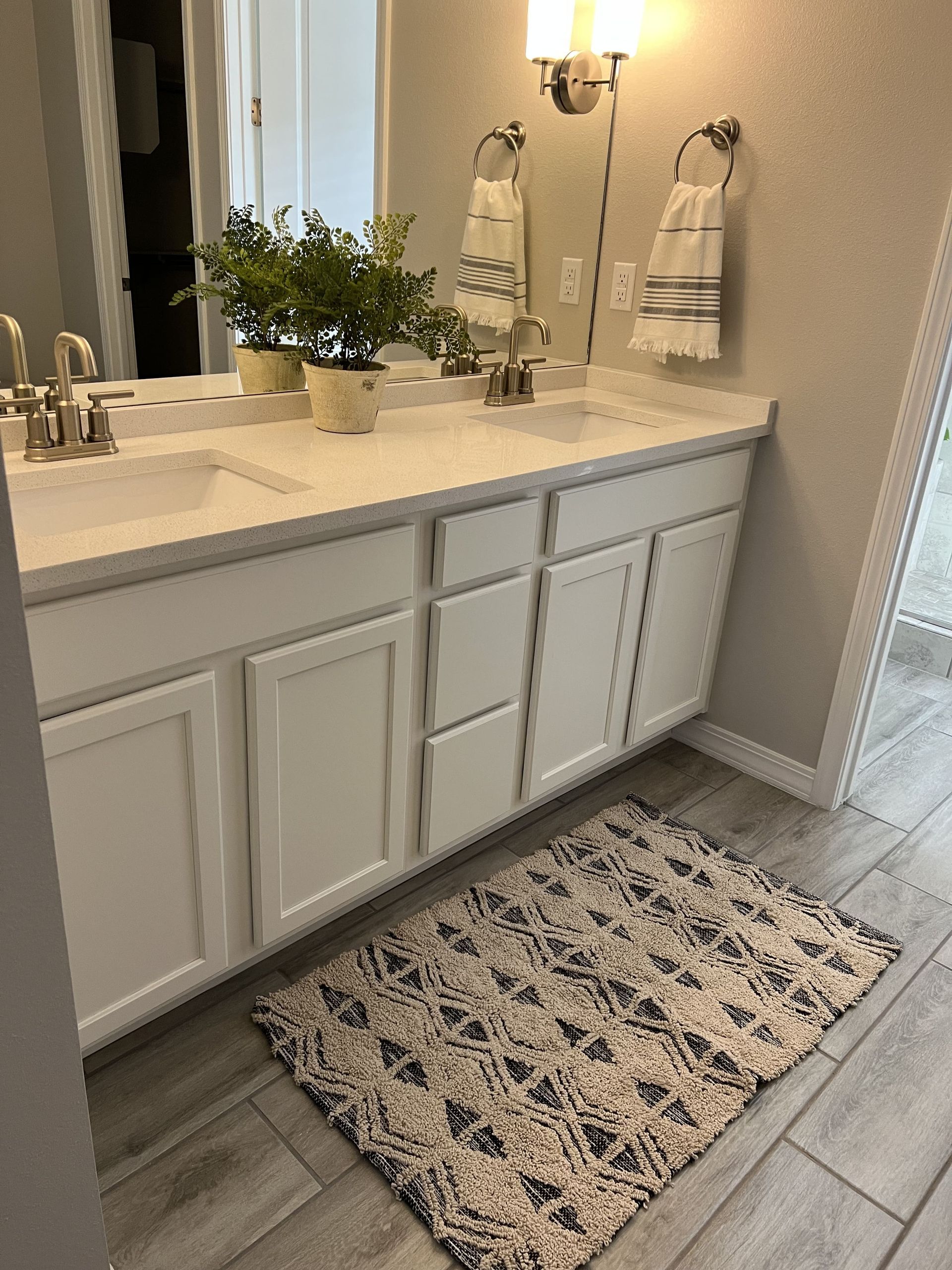 A bathroom with two sinks and a rug on the floor.
