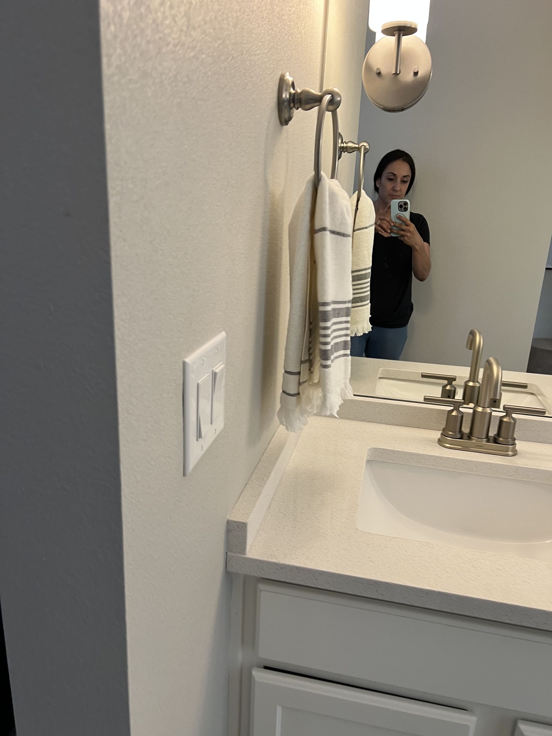 A woman is taking a picture of herself in a bathroom mirror.