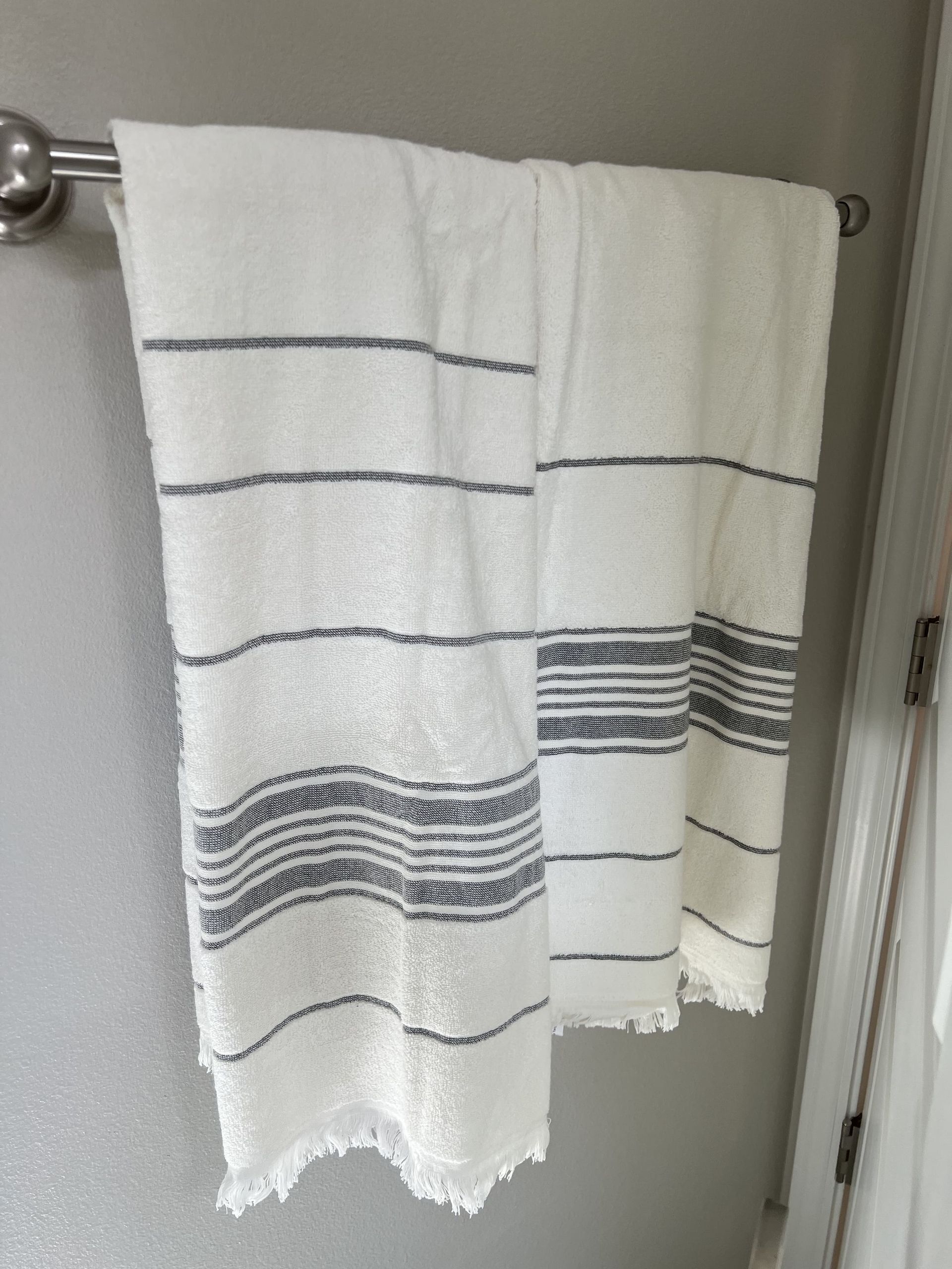 Two towels are hanging on a towel rack in a bathroom