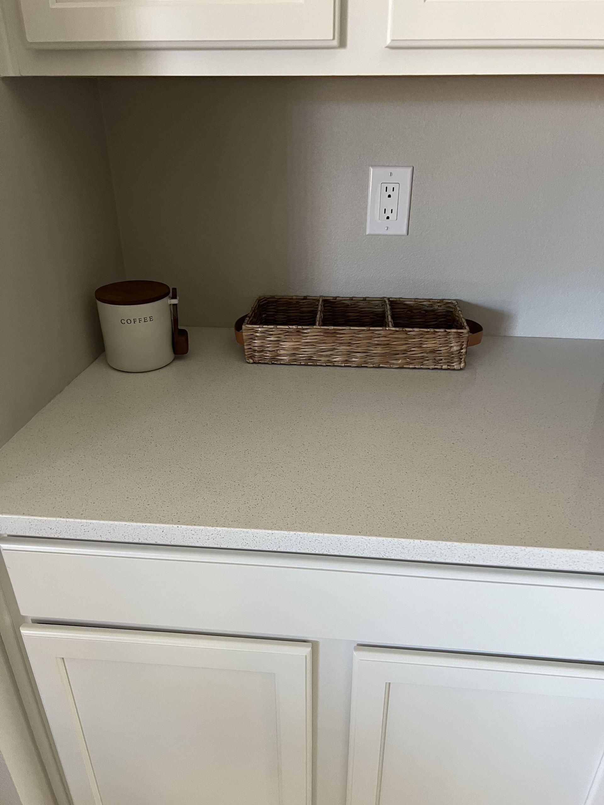 A white cabinet with a basket on top of it.