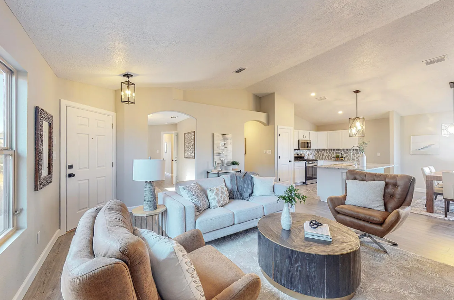 A living room with a couch , chairs , and a coffee table.