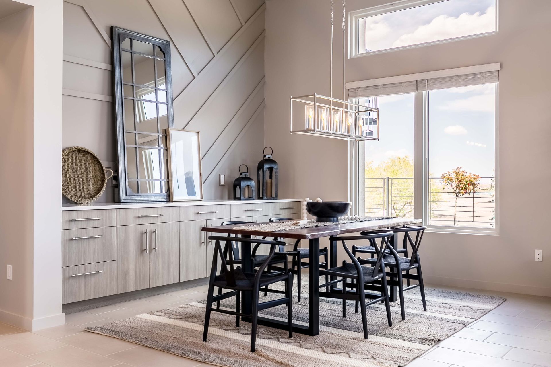 A dining room with a table and chairs and a large window.