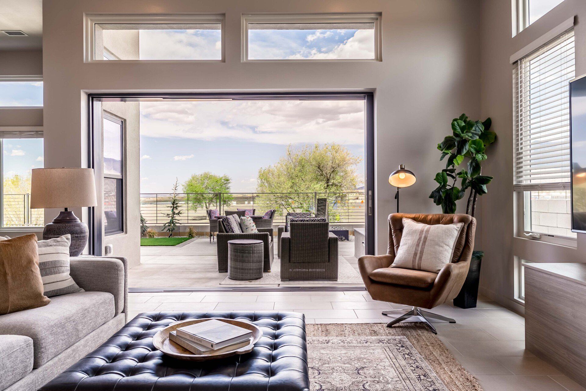 A living room with a couch , chair , coffee table and sliding glass doors leading to a patio.