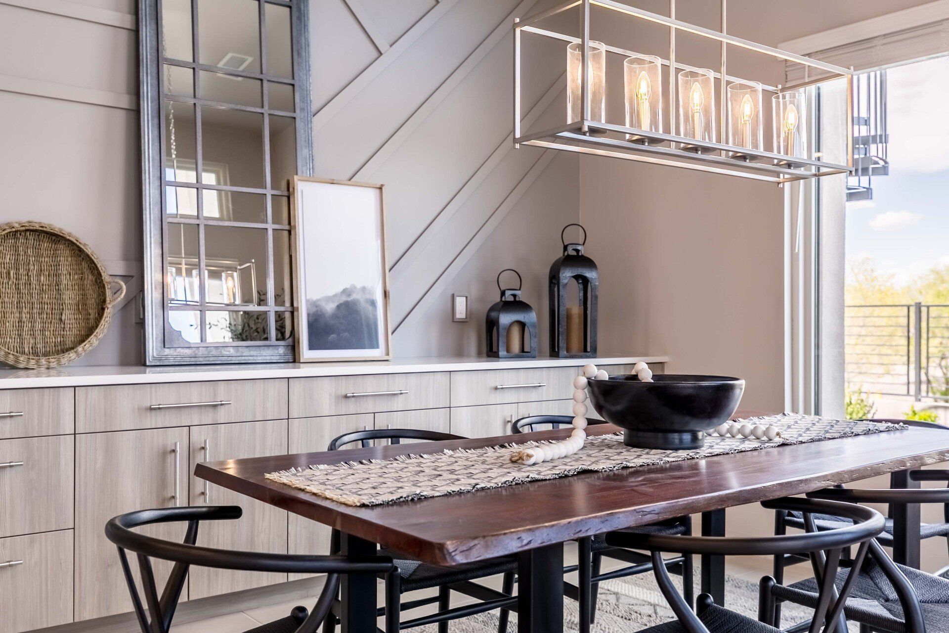 A dining room with a wooden table and chairs and a chandelier.