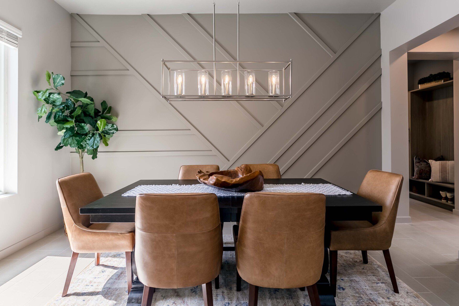 A dining room with a table and chairs and a chandelier hanging from the ceiling.