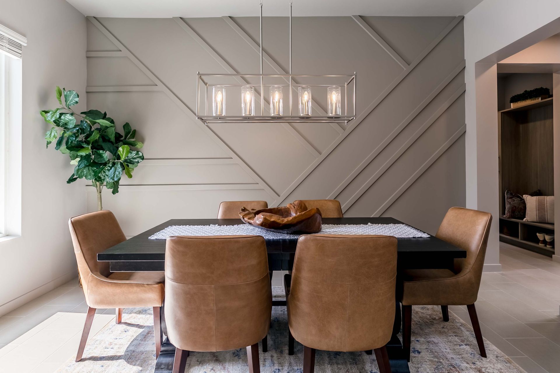 A dining room with a table and chairs and a chandelier hanging from the ceiling.