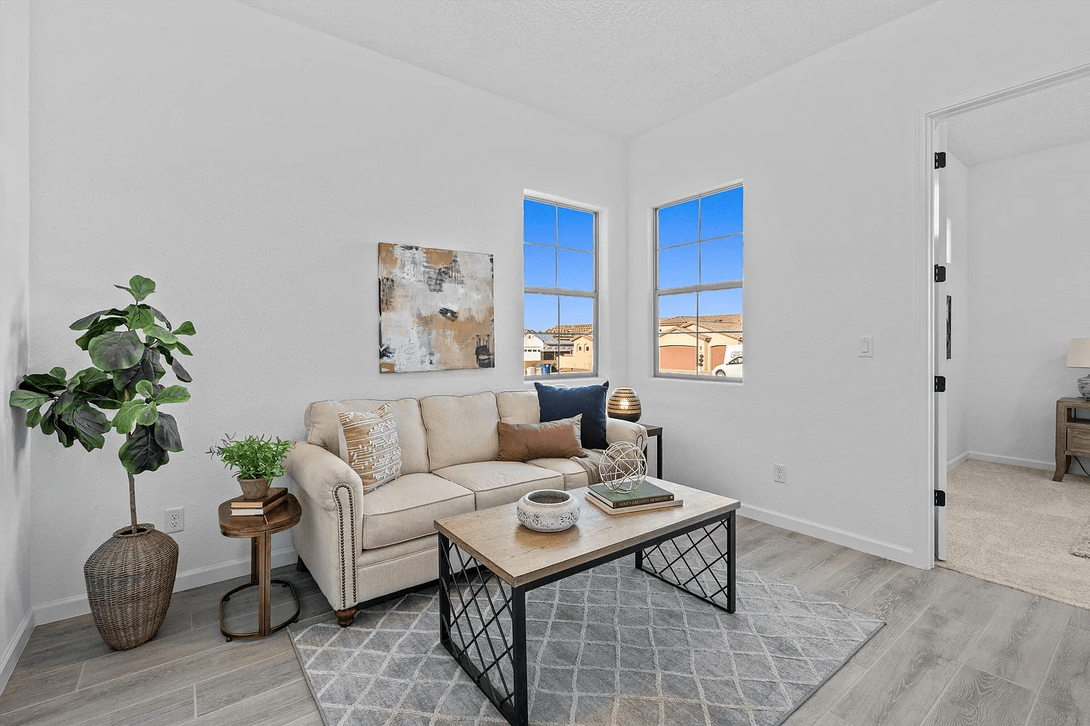A living room with a couch , coffee table , and two windows.