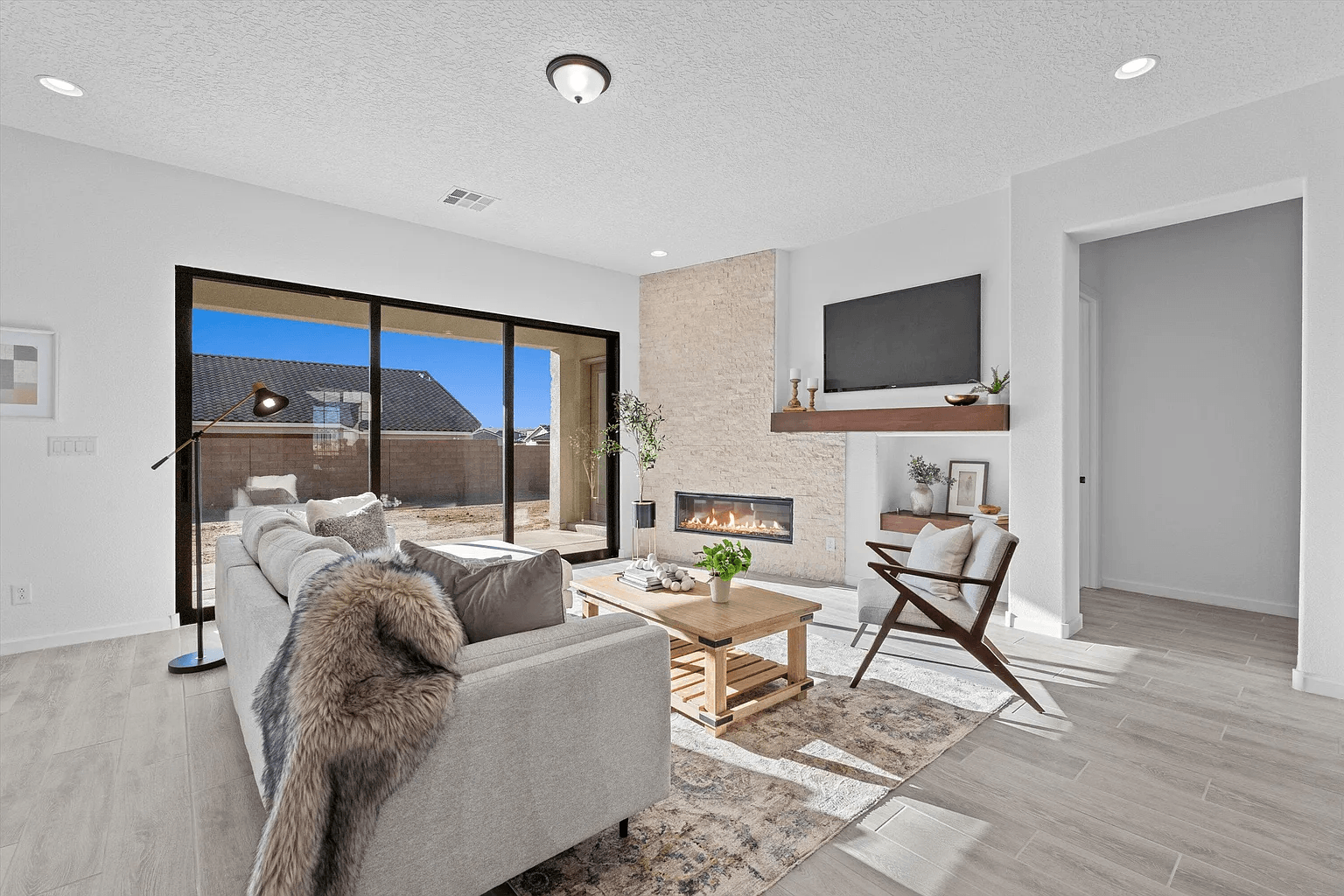 A living room with a couch , chair , coffee table , fireplace and television.