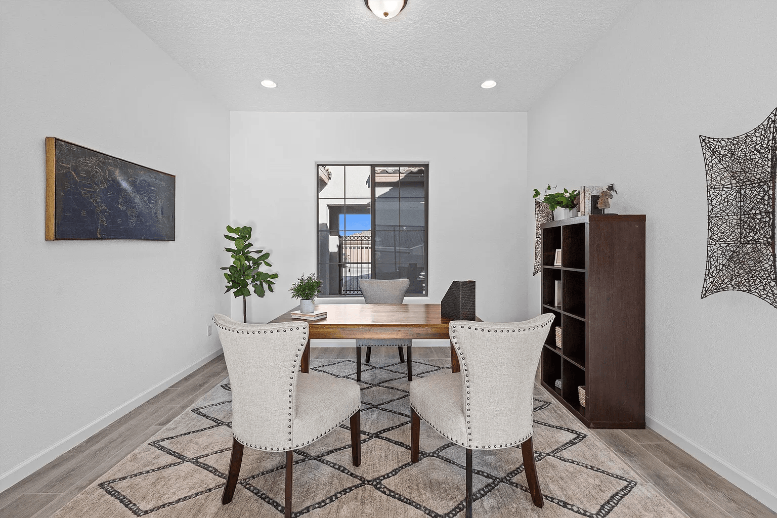 A dining room with a table and chairs and a rug.