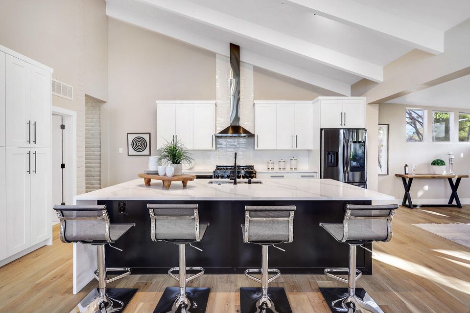 A kitchen with a large island and stools