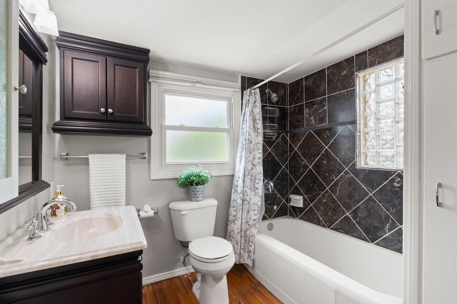 A bathroom with a toilet , sink , and bathtub.