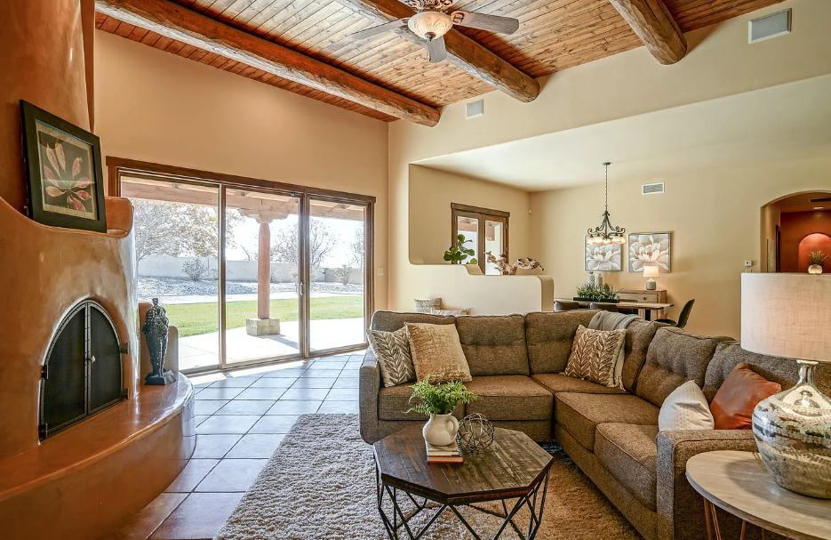 A living room with a sectional couch and a fireplace.