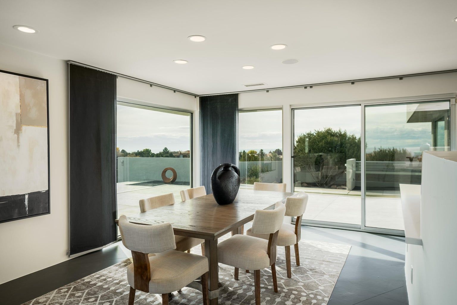 A dining room with a table and chairs and sliding glass doors