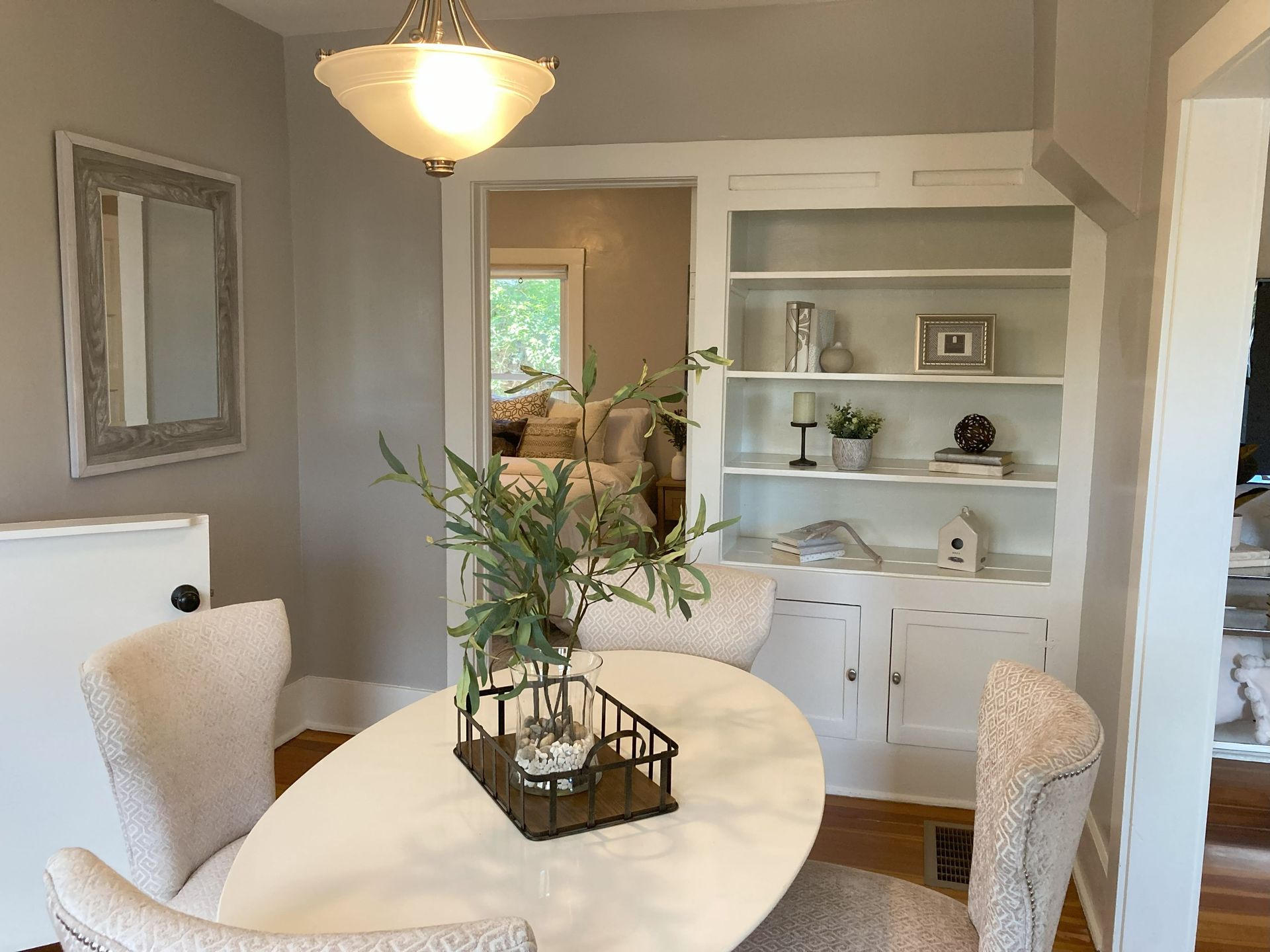 A dining room with a table and chairs and a bookshelf.
