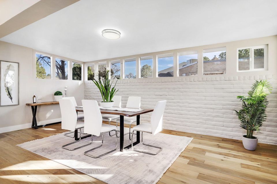A dining room with a table and chairs and a rug.