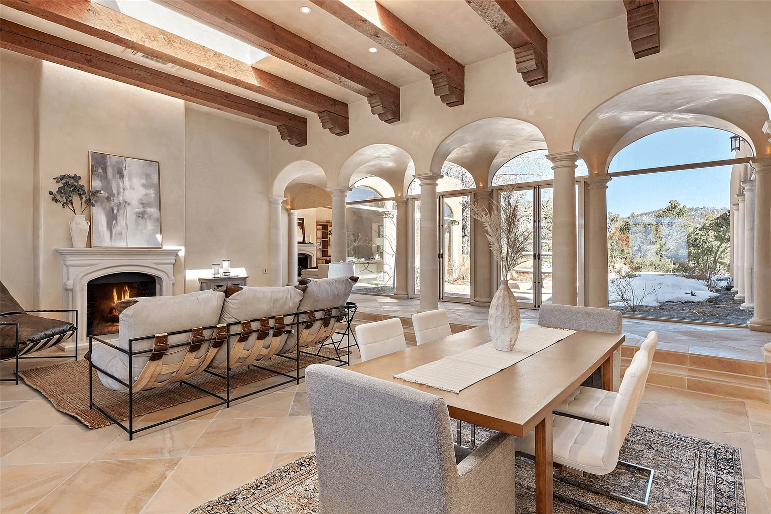 A living room with a fireplace , dining table , chairs and a couch.
