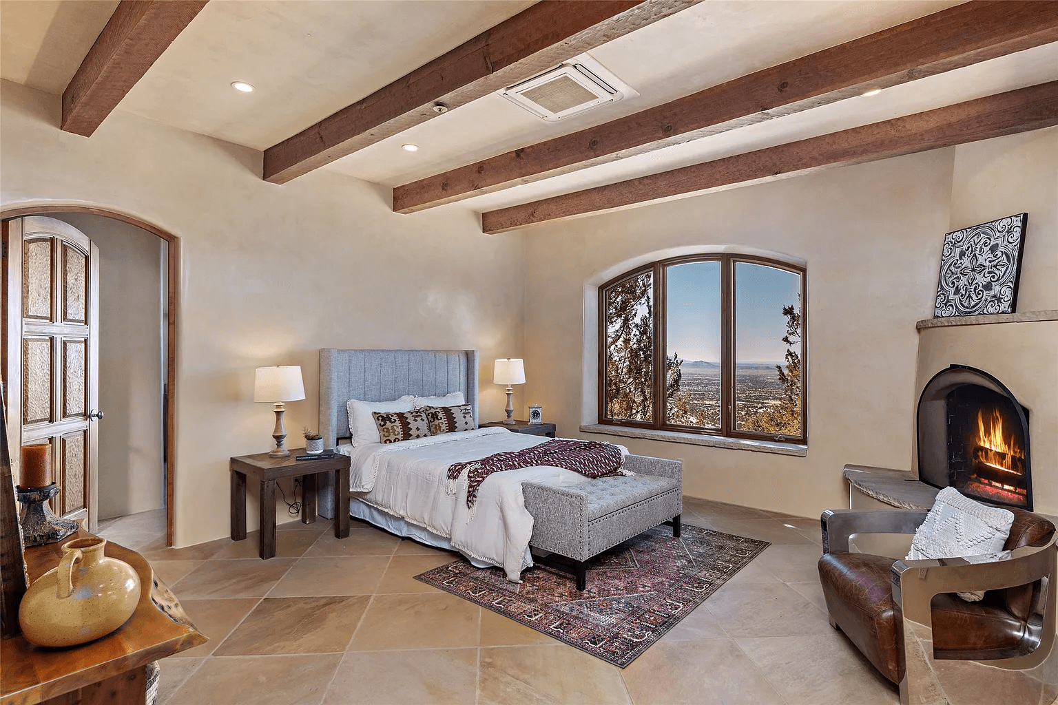 A bedroom with a fireplace and a large bed.