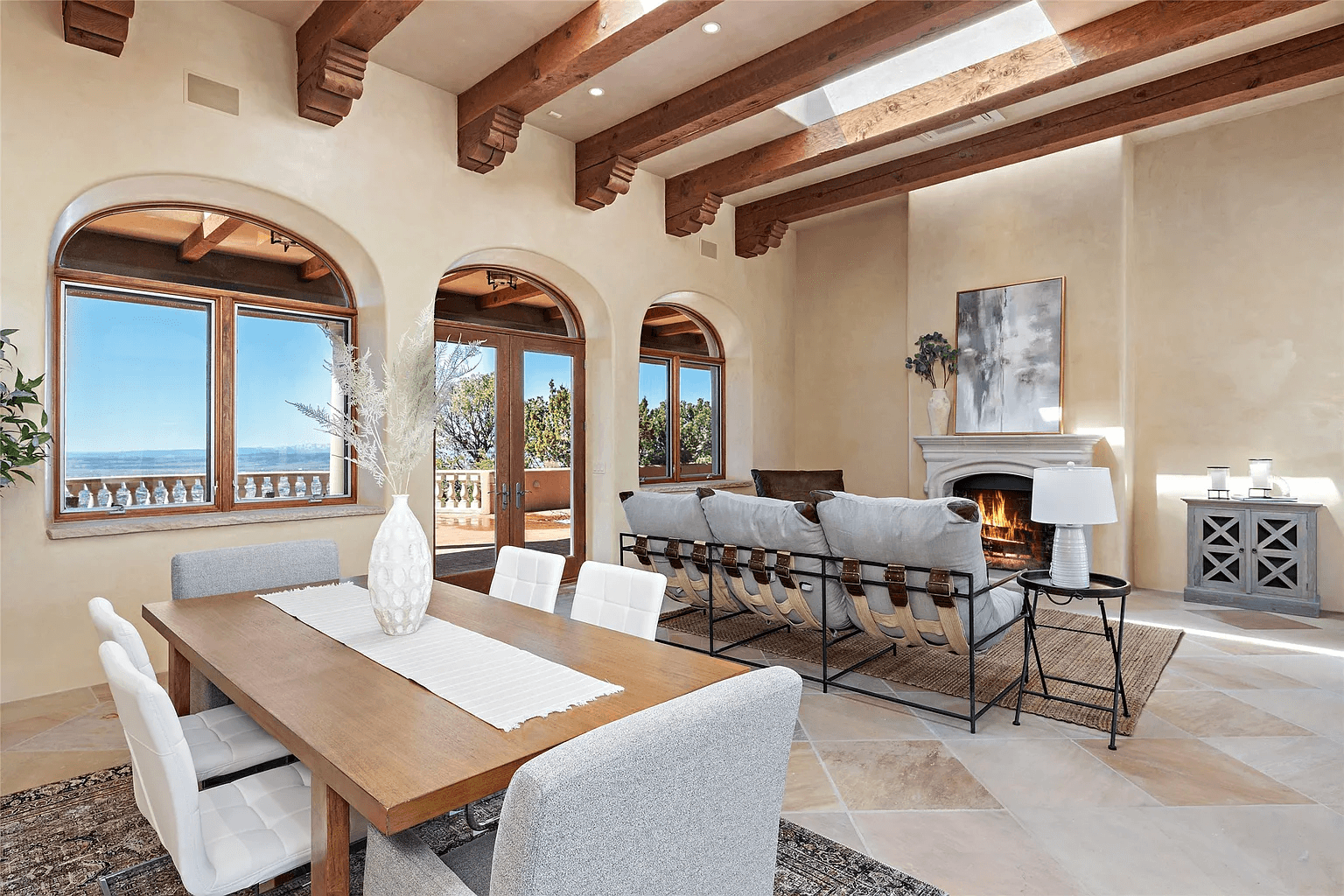 A living room with a dining table and chairs and a fireplace.