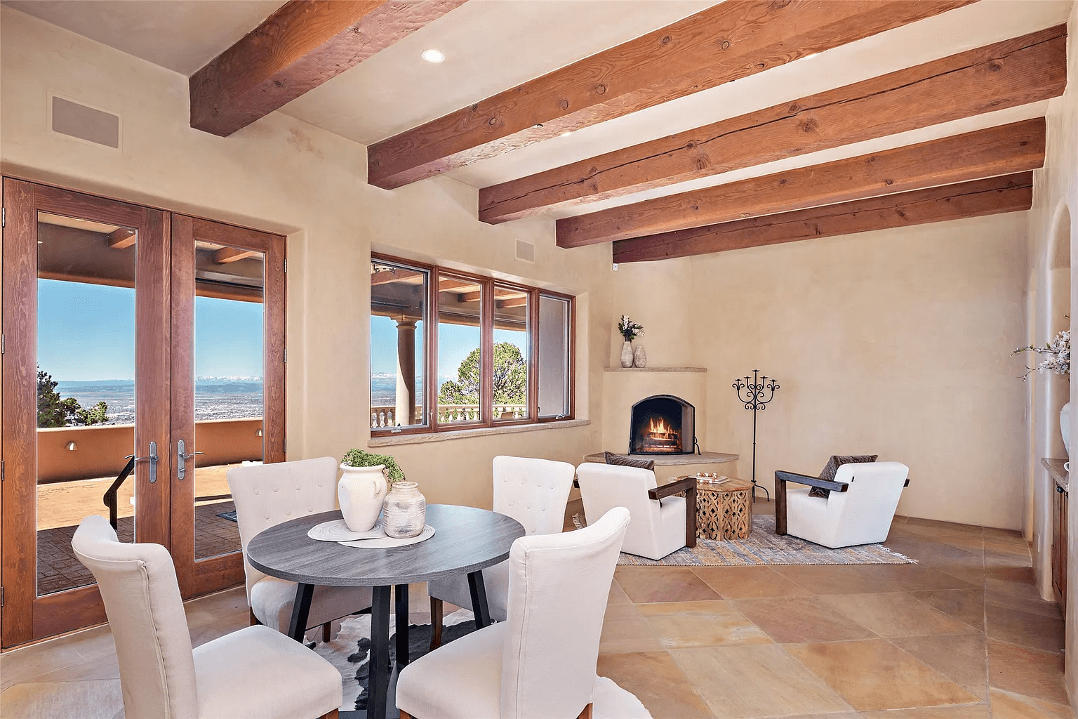 A living room with a table and chairs and a fireplace