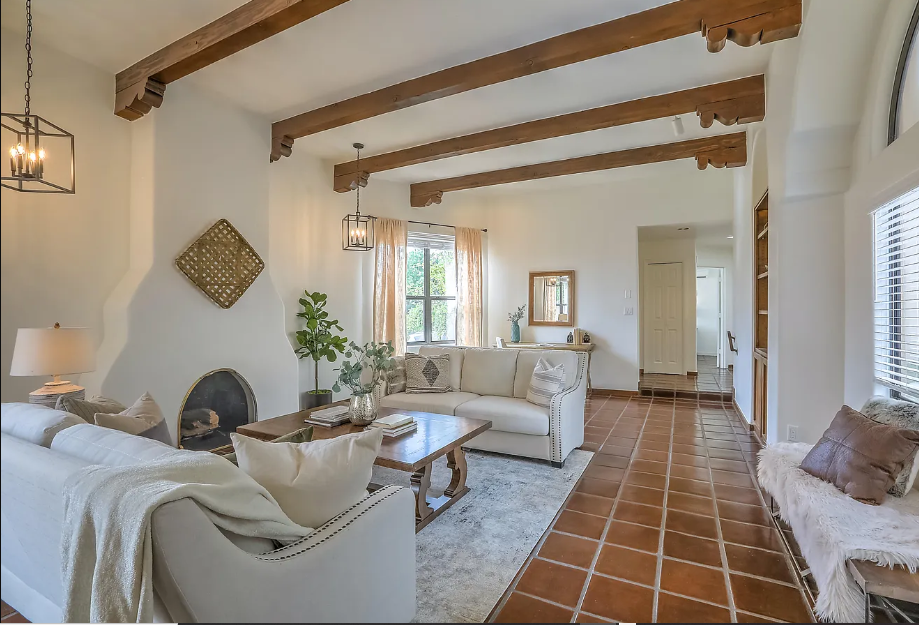 A living room with a couch , chair , coffee table and fireplace.
