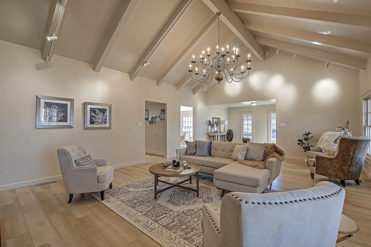 A living room with a couch , chairs , and a chandelier.