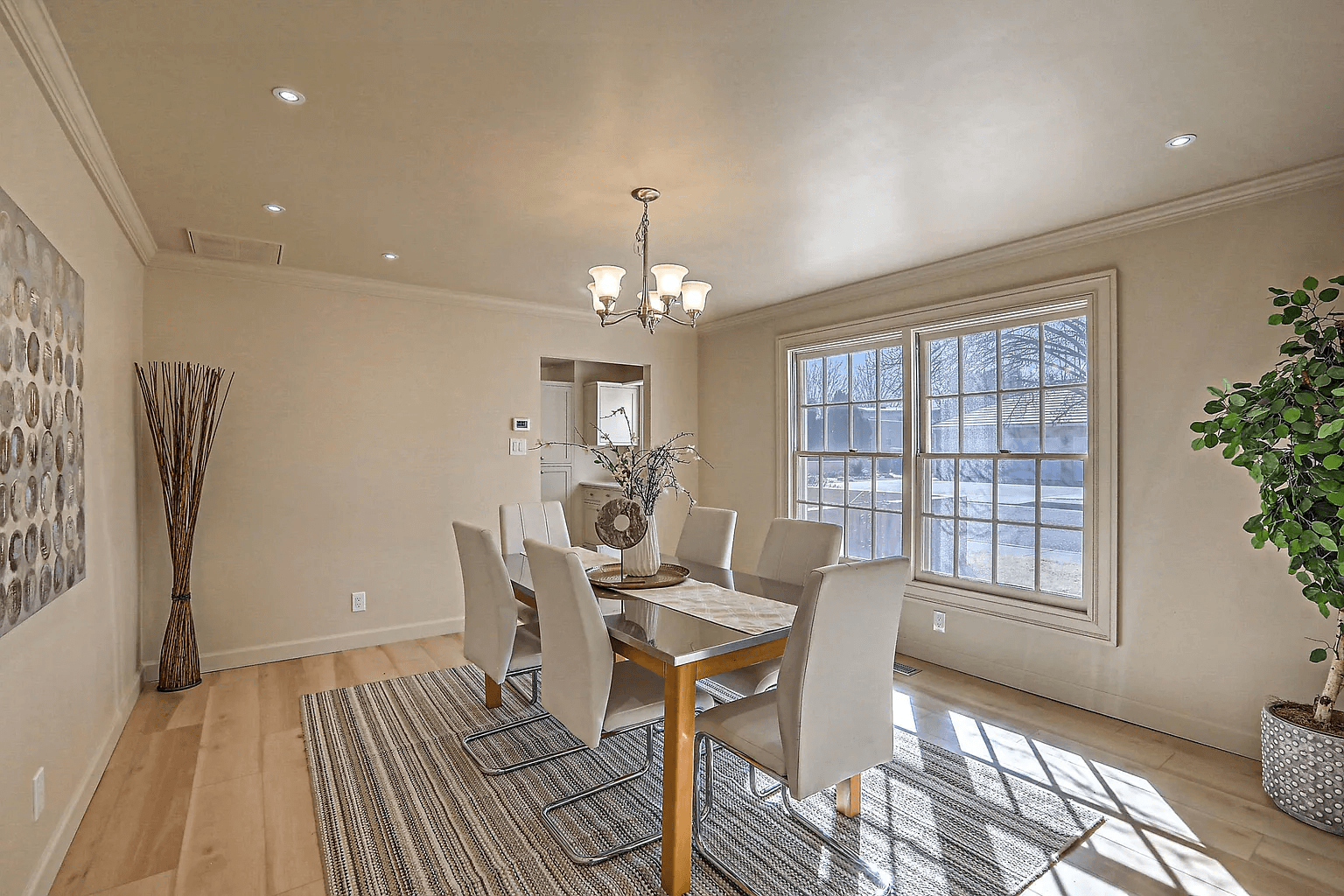 A dining room with a table and chairs and a chandelier.