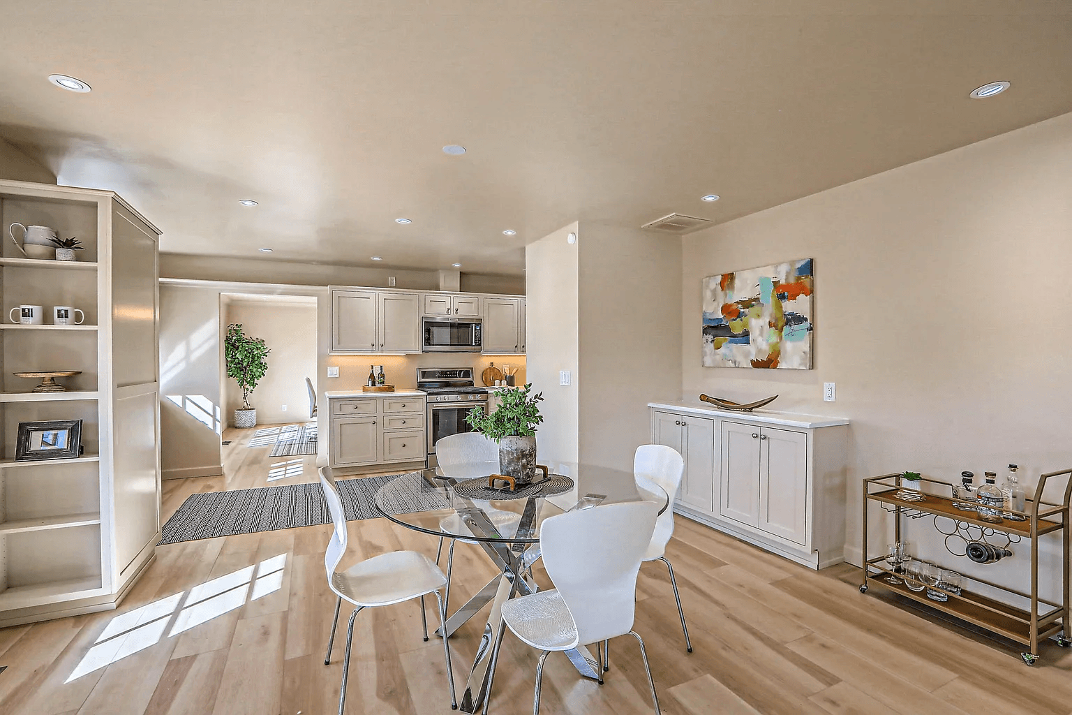 A living room with a dining table and chairs and a kitchen.
