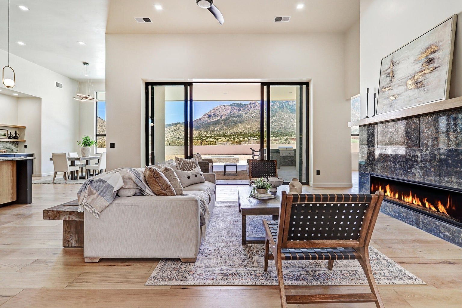 A living room with a couch , chair , fireplace and sliding glass doors.