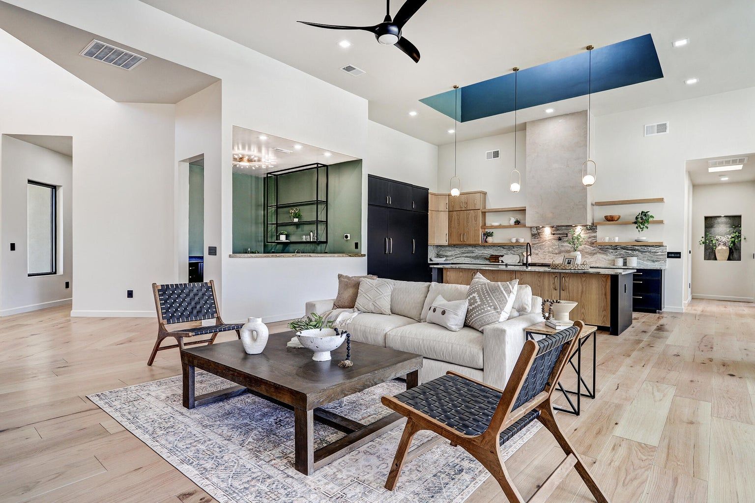 A living room with a couch , chairs , coffee table and ceiling fan.