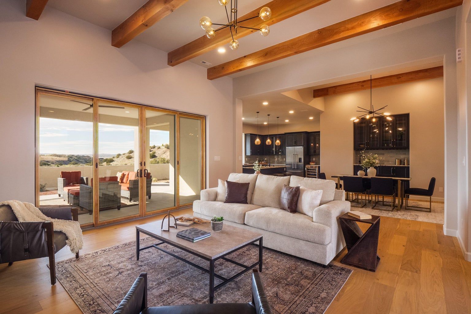 A living room with a couch , chairs , coffee table and sliding glass doors.