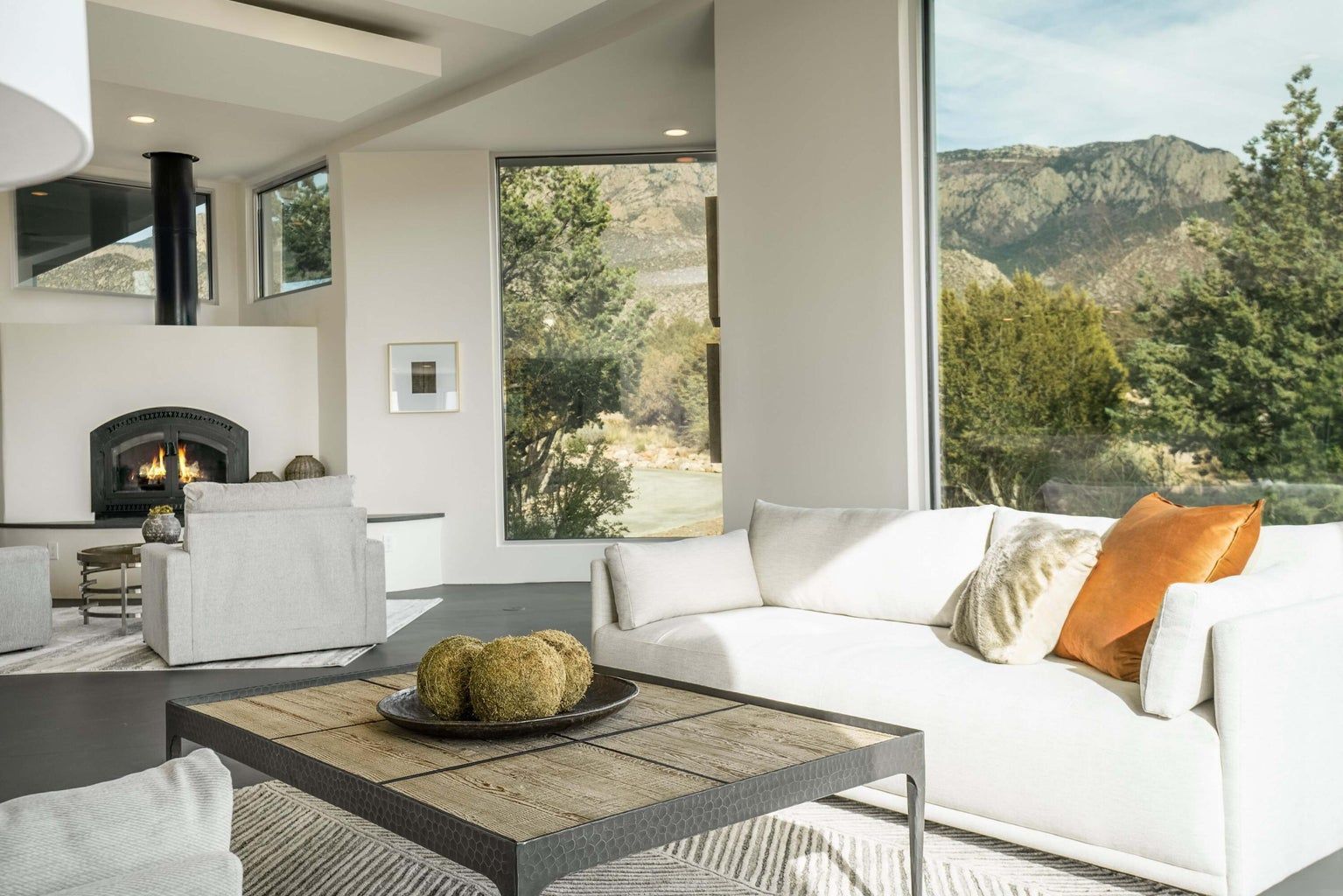 A living room with a couch , chairs , coffee table and fireplace.