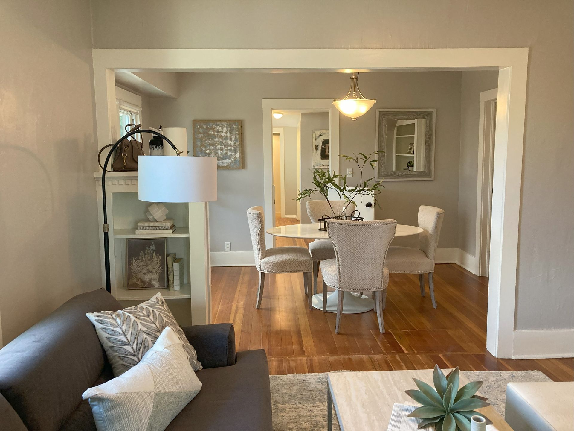A living room with a couch , table , chairs and a lamp.