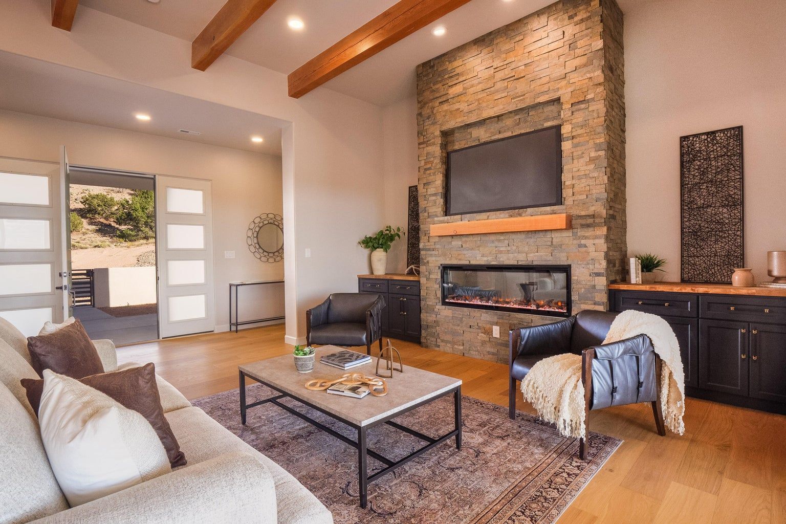 A living room with a couch , chairs , coffee table and fireplace.