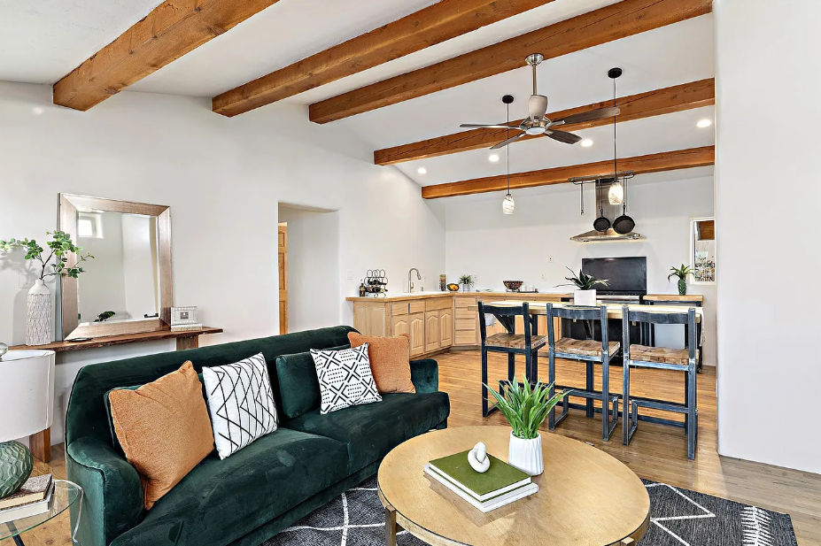 A living room with a green couch and a round coffee table.