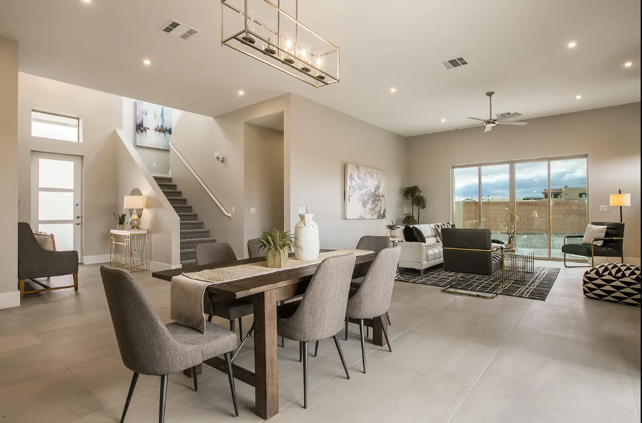 A living room with a dining table and chairs and a staircase.