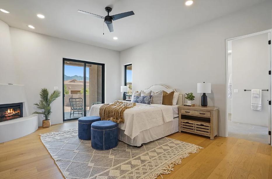 A bedroom with a large bed and a fireplace.