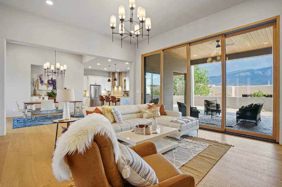 A living room with a couch , chair , coffee table and sliding glass doors.