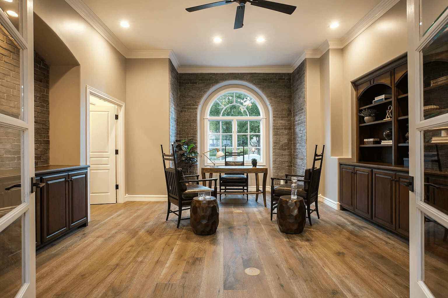 A living room with hardwood floors and a ceiling fan.