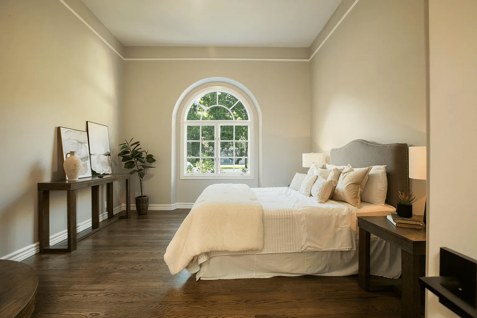 A bedroom with a large bed and a large window.
